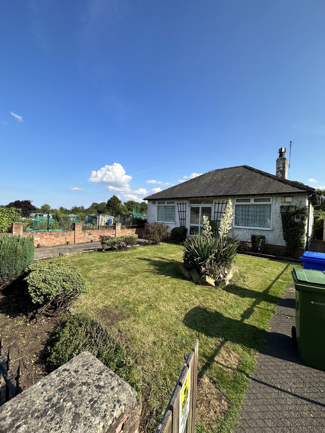 Neatly mown front lawn and planted borders at a bungalow