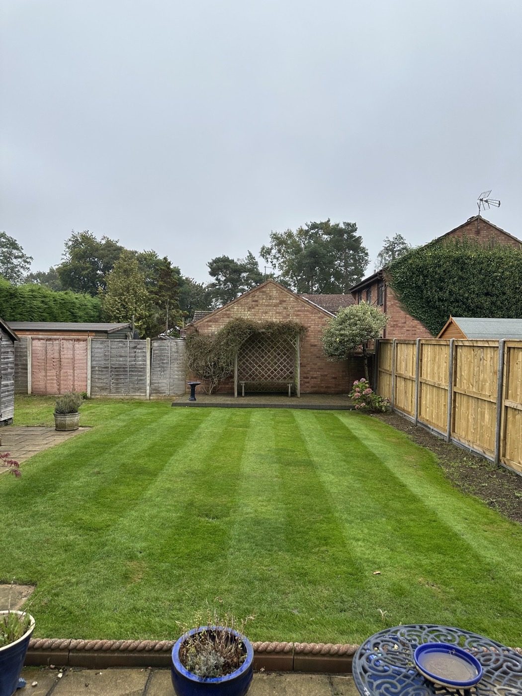 A large lawn finished with clean mowing stripes after a maintenance visit